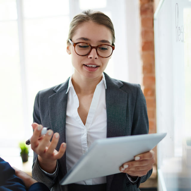 Woman in business outfit reading off of a tablet